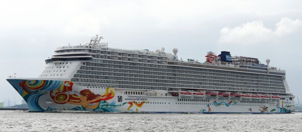 The Norwegian Getaway cruise ship, with its colorful mermaid hull art, sailing on open water